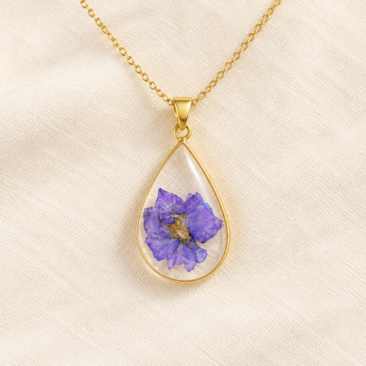 Collar de gota con flor violeta prensada en resina sobre tela de lino
