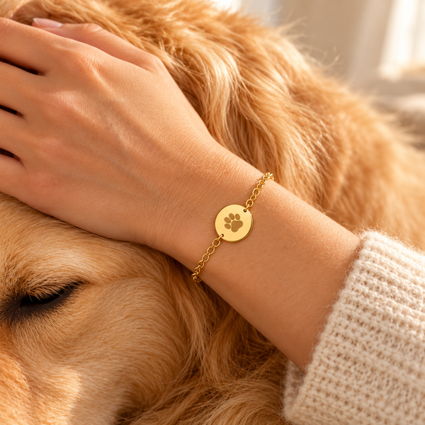 Pulsera huellita dorada usada junto a un perro